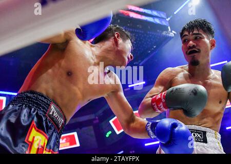 Bangkok, Thailand. Dezember 2023. Chaiyapruk Chainikom (rechts) im Austausch mit Xiaosong Zhang (links) während ihres professionellen Boxkampfes bei Spaceplus in Bangkok. Quelle: SOPA Images Limited/Alamy Live News Stockfoto