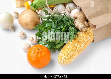 Einkaufstasche aus Papier mit verschiedenen frischen Produkten auf weißem Hintergrund Stockfoto