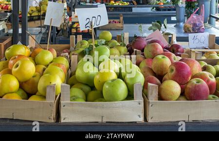 Haufen von rohen Bio-Apfelfrüchten in Holzkisten, die draußen am Marktstand verkauft werden Stockfoto