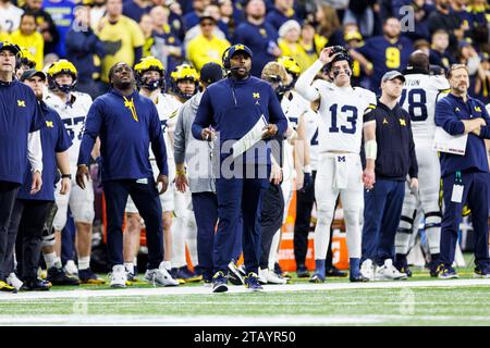 Indianapolis, Indiana, USA. Dezember 2023. Die Angriffskoordinatorin von Michigan, Sherrone Moore, nennt das Spiel von der Seitenlinie während der NCAA-Football-Action zwischen den Michigan Wolverines und den Iowa Hawkeyes im Lucas Oil Stadium in Indianapolis, Indiana. John Mersits/CSM (Credit Image: © John Mersits/Cal Sport Media). Quelle: csm/Alamy Live News Stockfoto