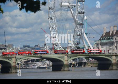 Westminster Bridge mit Doppeldeckerbussen vor dem London Eye Stockfoto