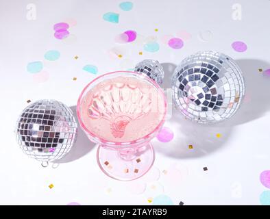 Discokugeln und Champagner mit Konfetti in einer Partyszene in traumhaften Pastellfarben Stockfoto