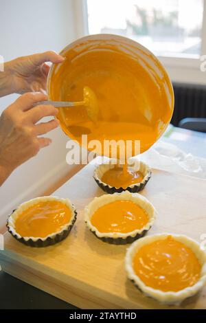 Nahaufnahme von Frauenhänden, die kleine Kürbiskuchen backen. Thanksgiving Stockfoto