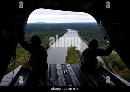 Von links aus schauen der US Army Sgt. Nathan Hillis und der US Army Sgt. Joshua Maker, Bravo Company, beide CH-47 Chinook Flugingenieure mit 1-169th Aviation, Alabama Army National Guard, am 12. Oktober 2023 auf die hintere Rampe der CH-47 Chinook ihrer Einheit, irgendwo oberhalb von Nord-Alabama. Die Mitglieder der 1-169 AVN der Armee-Nationalgarde bieten manchmal Chinook-Flüge zu den Flugzeugen der 117 ARW an, um ihren Soldaten zu üben, Passagiere an Bord zu haben, und für Flugleute in nicht-Luftfahrtrollen eine Flugmöglichkeit zu bieten; beide Einheiten können die gemeinsame Umgebung, in der sie arbeiten, optimal nutzen. Stockfoto