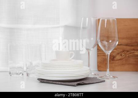 Sauberes Geschirr auf dem hellen Tisch in der Küche Stockfoto