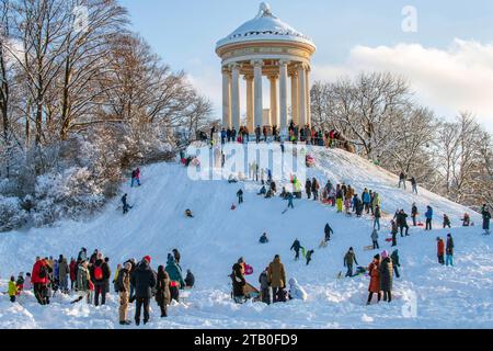 Rodeln im Englischen Garten, Kinder fahren mit ihren Schlitten den Hügel am Monopteros herunter, München, Dezember 2023 Deutschland, München, 3. Dezember 2023, Rodeln im verschneiten Englischen Garten, Kinder fahren mit ihren Schlitten begeistert den Hang am Monopteros herunter, viele Eltern mit Kindern nutzen den sonnigen Wintertag für einen Sonntagsspaziergang im Englischen Garten, Temperaturen bei -10 Grad, klirrend kalt, Wochenende, Winter, 2023, Bayern, *** Rodeln im Englischen Garten, Kinder fahren mit dem Schlitten den Berg hinunter im Monopteros, München, Dezember 2023 Deutschland, München Stockfoto