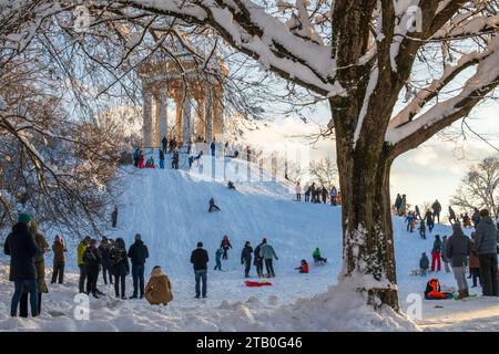 Rodeln im Englischen Garten, Kinder fahren mit ihren Schlitten den Hügel am Monopteros herunter, München, Dezember 2023 Deutschland, München, 3. Dezember 2023, Rodeln im verschneiten Englischen Garten, Kinder fahren mit ihren Schlitten begeistert den Hang am Monopteros herunter, viele Eltern mit Kindern nutzen den sonnigen Wintertag für einen Sonntagsspaziergang im Englischen Garten, Temperaturen bei -10 Grad, klirrend kalt, Wochenende, Winter, 2023, Bayern, *** Rodeln im Englischen Garten, Kinder fahren mit dem Schlitten den Berg hinunter im Monopteros, München, Dezember 2023 Deutschland, München Stockfoto