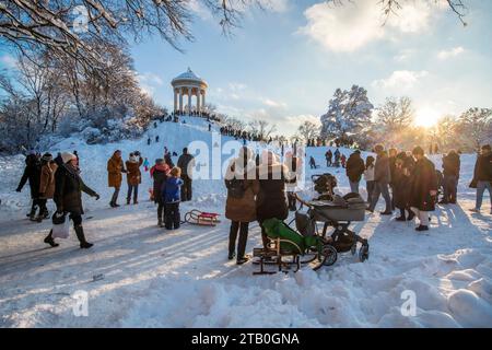 Rodeln im Englischen Garten, Kinder fahren mit ihren Schlitten den Hügel am Monopteros herunter, München, Dezember 2023 Deutschland, München, 3. Dezember 2023, Rodeln im verschneiten Englischen Garten, Kinder fahren mit ihren Schlitten begeistert den Hang am Monopteros herunter, viele Eltern mit Kindern nutzen den sonnigen Wintertag für einen Sonntagsspaziergang im Englischen Garten, Sonntagnachmittag um 16 Uhr, kurz vor Sonnenuntergang, Temperaturen bei -10 Grad, klirend kalt, Wochenende, Winter, 2023, Bayern, *** Rodeln im Englischen Garten fahren Kinder mit ihren Schlitten den Hügel A hinunter Stockfoto