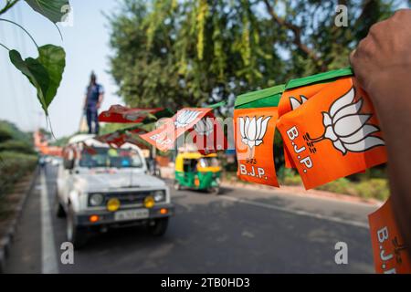 Neu-Delhi, Indien. Dezember 2023. Ein BJP-Arbeiter schmückt die Straße mit einem Girlande aus Parteiflaggen, um den Sieg bei den Wahlen zur Versammlung von Madhya Pradesh, Chhattisgarh und Rajasthan im Hauptquartier der BJP zu feiern. In Indien fanden vor kurzem vier Wahlen zur Staatsversammlung statt, und die Bharatiya Janata Party (BJP) wird die Regierung in Madhya Pradesh, Chhattisgarh und Rajasthan bilden. (Foto: Pradeep Gaur/SOPA Images/SIPA USA) Credit: SIPA USA/Alamy Live News Stockfoto