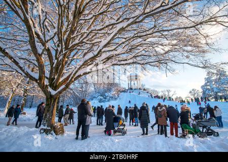 Sonniger Wintertag im Englischen Garten, Eltern schauen Kinder beim Rodeln am Monopteros zu, München, Dezember 2023 Deutschland, München, 3. Dezember 2023, viele Münchner genießen den sonnigen Wintertag bei einem Spaziergang im verschneiten Englischen Garten, Kinder fahren mit ihren Schlitten begeistert den Hang am Monopteros herunter, viele Eltern mit Kindern unterwegs, malerisch verschneite Bäume, Temperaturen bei -10 Grad, klirrend kalt, Wochenende, Winter, 2023, Bayern, *** sonniger Wintertag im Englischen Garten, Eltern beobachten Kinder beim Rodeln im Monopteros, München, Dezember 2023 Stockfoto