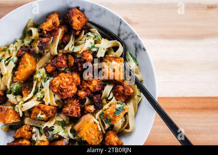 Pflanzliche Fettuccine-Nudeln mit Spinat Kürbis und Tofu-Stückchen, gesunde vegane Lebensmittelrezepte Stockfoto