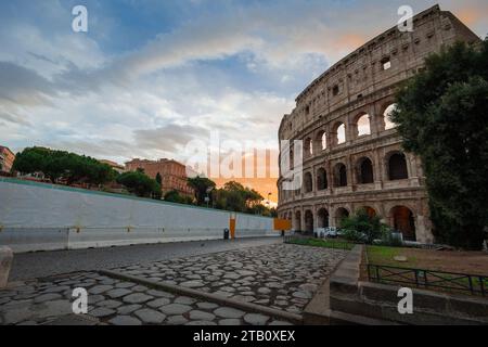 Blick am frühen Morgen auf das kolosseum in Rom, roter und blauer Himmel mit Sonne, die gerade über dem großen berühmten Amphitheater aufgeht. Herbsteinstellung. Stockfoto