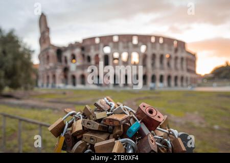 Liebe Vorhängeschlösser am frühen Morgen vor dem kolosseum in Rom, roter und blauer Himmel mit Sonne, kurz davor, über dem großen berühmten Amphitheater aufzusteigen. Stockfoto