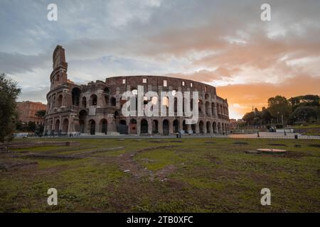 Blick am frühen Morgen auf das kolosseum in Rom, roter und blauer Himmel mit Sonne, die gerade über dem großen berühmten Amphitheater aufgeht. Herbsteinstellung. Stockfoto