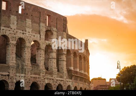 Blick am frühen Morgen auf das kolosseum in Rom, roter und blauer Himmel mit Sonne, die gerade über dem großen berühmten Amphitheater aufgeht. Herbsteinstellung. Stockfoto