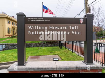 Ein Denkmalschild mit der Aufschrift William Howard Taft National Historic Site und National Park Service steht vor dem gelben Haus, Cincinnati, Ohio. Stockfoto