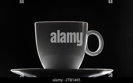 Leere Kaffeetasse aus Keramik auf einer Untertasse. Porzellan isoliert auf grauem Hintergrund. Dynamisches kontrastreiches Studiobild. Stockfoto