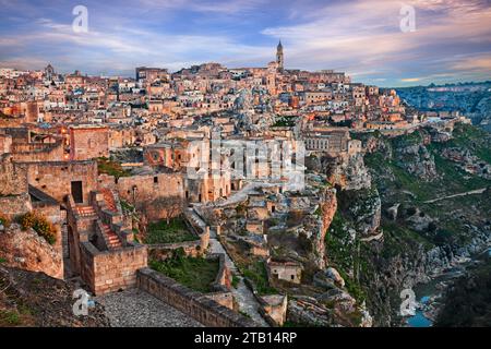 Matera, Basilicata, Italien: Landschaft am Morgen der Altstadt namens Sassi mit den alten Höhlenhäusern und dem Bach am Fuße der tiefen Schlucht Stockfoto