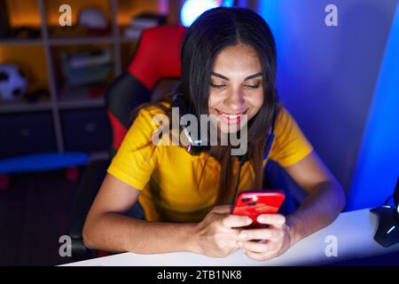 Junge wunderschöne araberin streamt mit Computer und Smartphone im Spielzimmer Stockfoto