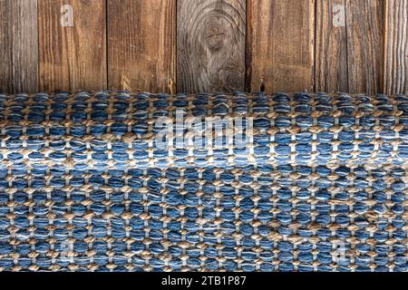 Handgewebter Teppich mit geometrischem Denim-Bereich auf Holzboden. Stockfoto