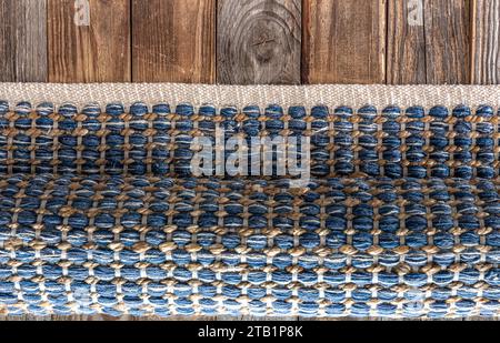 Handgewebter Teppich mit geometrischem Denim-Bereich auf Holzboden. Stockfoto