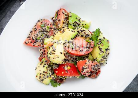 Salat mit Tomaten, Zucchini, geriebenem Knoblauch mit vielen Sesamsamen, Blick von oben Stockfoto