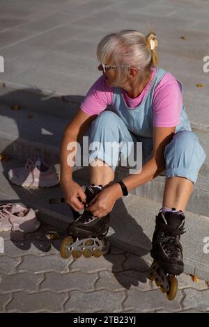 Frauen mittleren Alters Rollschuhlaufen in der Stadt. Unterhaltung mittleren Alters. Stockfoto
