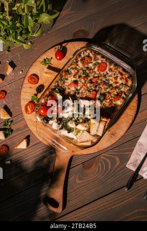 Rindfleisch Lasagne mit Mozzarella, Tomaten und Basilikum auf einem Holzbrett Stockfoto