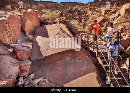 Touristen bei Felsstichen von Twyfelfontein, Damaraland, Namibia, Afrika Stockfoto