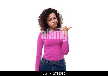 Junge Führerin mit lockigen schwarzen Haaren, die einen Fliederpullover trägt, um Ideen zu generieren Stockfoto