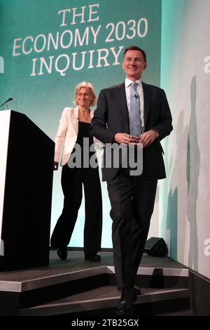 Chefredakteur des Ökonomen Zanny Minton Beddoes (links) und Kanzler des Finanzministeriums Jeremy Hunt bei der Resolution Foundation-Konferenz im QEII Centre in London. Bilddatum: Montag, 4. Dezember 2023. Stockfoto