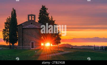 Ein 16:9-Foto von einem Sonnenuntergang an der berühmten Cappella della Madonna di Vitaleta im Val d'Orcia in der toskanischen Landschaft, zwischen San Quirico d'Or Stockfoto