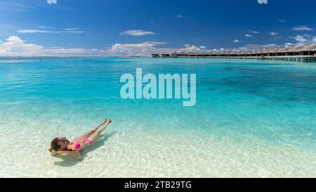 Blonde weiße Frau mit rosafarbenem Bikini im Anantara Dhigu und Vela Luxushotel Maldives Stockfoto