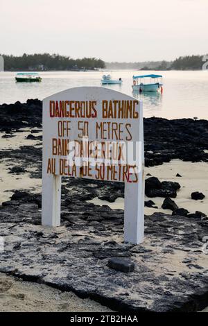 Gefahrenwarnschild am Blue Bay Beach auf Mauritius Island mit Booten Stockfoto