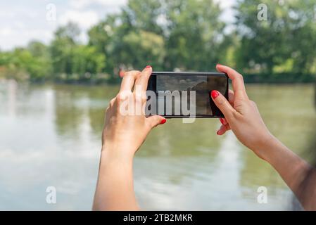 Frauenhände machen Fotos von der Natur. Stockfoto