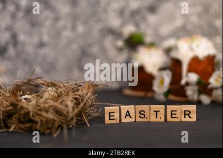 Ostertext auf Holztafeln. Wachteleier im Nest. Stockfoto