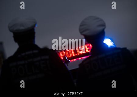 Stuttgart, Deutschland. November 2023 30. Zwei Polizisten stehen während eines Fotoshootings vor einem Polizeifahrzeug (posierte Szene). Quelle: Marijan Murat/dpa/Alamy Live News Stockfoto