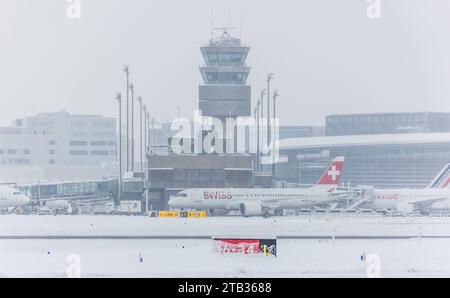 Flughafen Zürich ein Airbus A220-371 von Swiss International Airlines steht bei starkem Schneefall vor dem Terminal B und dem Kontrollturm des Flughafens Zürich. Registrierung HB-JCU. Zürich, Schweiz, 02.12.2023 *** Flughafen Zürich ein Airbus A220 371 der Swiss International Airlines steht vor Terminal B und dem Kontrollturm des Flughafens Zürich Registration HB JCU Zürich, Schweiz, 02 12 2023 bei starkem Schneefall Credit: Imago/Alamy Live News Stockfoto