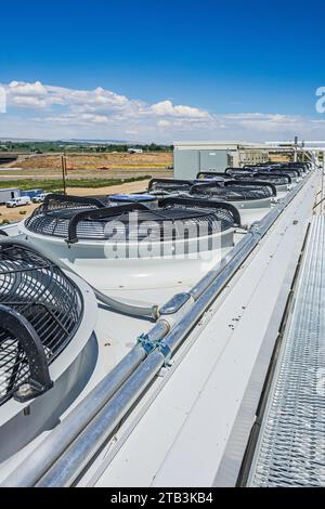 Elektrische Ventilatoren auf einem adiabatischen Kondensator auf dem Dach eines CO2-Kühllagers (Industriekühlung). Stockfoto