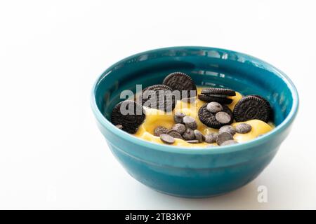 Ein Nahbild einer Schüssel Mangosorbet mit Schokoladenchips und Keksen. Stockfoto