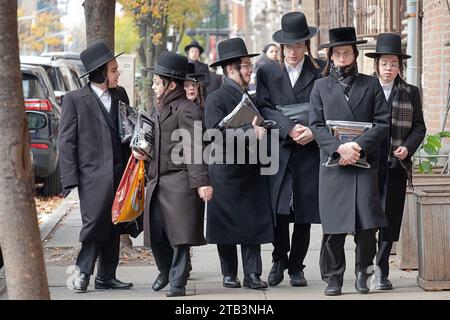 Eine Gruppe orthodoxer jüdischer Jungs spazieren zusammen auf der Flushing Avenue, während sie vom Morgengottesdienst zurückkehren. In Brooklyn, New York. Stockfoto