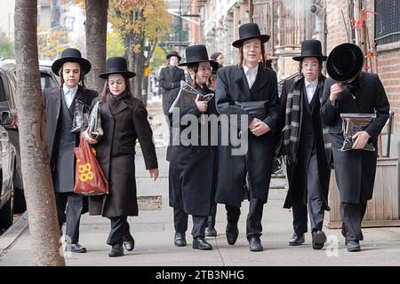 Eine Gruppe orthodoxer jüdischer Jungs spazieren zusammen auf der Flushing Avenue, während sie vom Morgengottesdienst zurückkehren. In Brooklyn, New York. Stockfoto