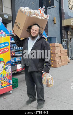 Posiertes Foto eines orthodoxen jüdischen Arbeiters, der Franczoz Brot an einen glatt Kosher Supermarkt in Williamsburg, Brooklyn, New York liefert. Stockfoto