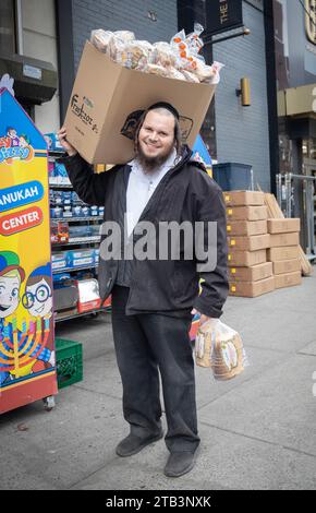 Posiertes Foto eines orthodoxen jüdischen Arbeiters, der Franczoz Brot an einen glatt Kosher Supermarkt in Williamsburg, Brooklyn, New York liefert. Stockfoto
