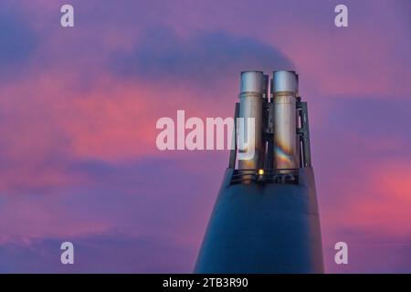 Großer Metalltrichter im Heck eines Schiffes mit Rauch und rosa Sonnenuntergang in der Atlantischen Ozean Fähre Stockfoto