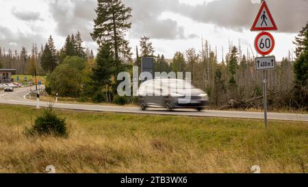 Graues Auto fährt schnell auf den Landstraßen mitten im Nationalwald im Harz niedersachsen in einer Geschwindigkeitsbegrenzungszone von 60 km/h am Tag Stockfoto