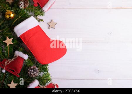 Rote Weihnachtsstrümpfe auf weißem hölzernem Hintergrund mit Weihnachtsdekoration, Sinterklaas St. Nikolaus Tag. Epiphany Befanas Strümpfe oder Santa C. Stockfoto