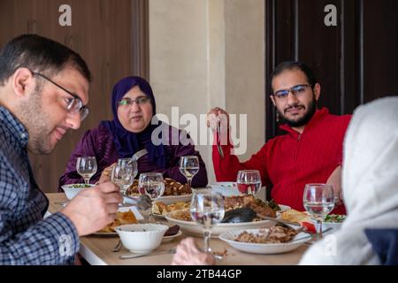 Familienessen mit Mitgliedern mehrerer Generationen im modernen Wohnzimmer Stockfoto