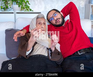 Ein arabischer Mann und seine Mutter unterhalten sich tief im Wohnzimmer Stockfoto