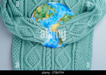 Ärmel aus Strickpullover umarmen den Planeten. Kleidung für verantwortungsbewussten Konsum. Umweltfreundlichkeit und nachhaltige Mode Stockfoto